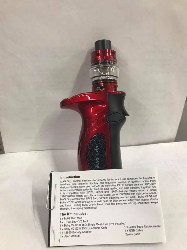 Red and black vape device standing upright with a product information card in front.