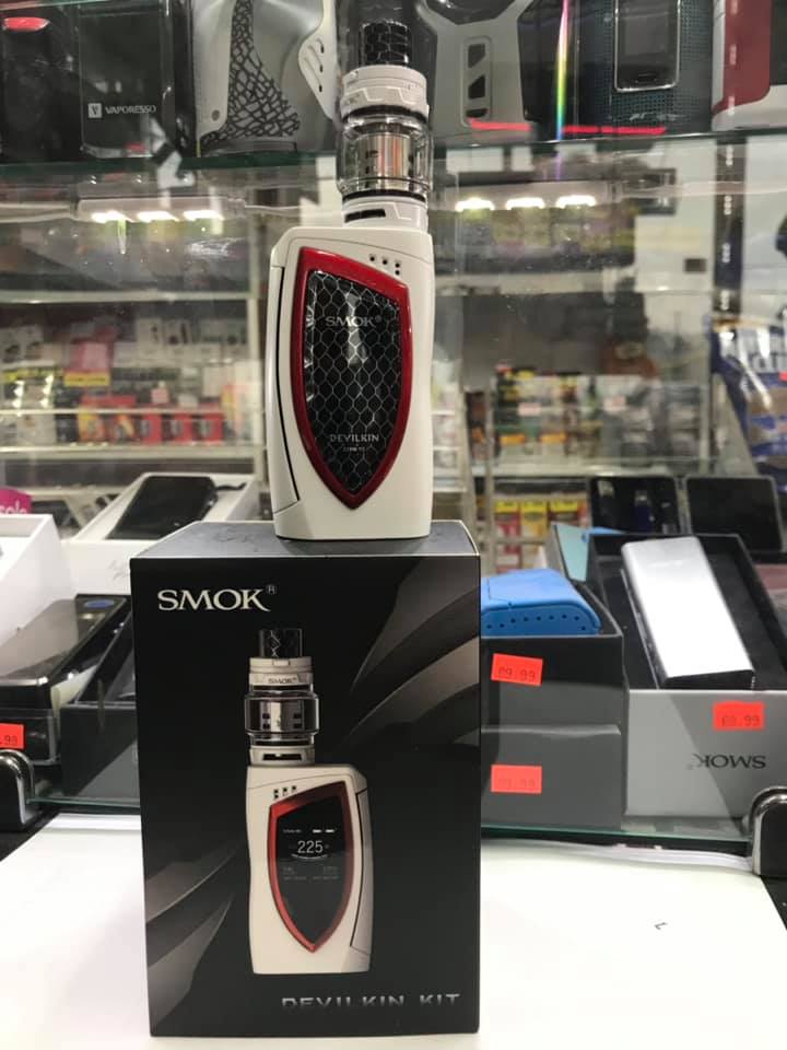 White and black SMOK vape device with red accents displayed on top of its product box in a store.